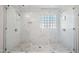 Stunning glass shower boasts dual shower heads, marble tile, and a light-filled glass block window at 2121 Karns Pl, Raleigh, NC 27614