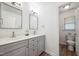 Bathroom with double vanity, gray cabinets, modern fixtures and a separate toilet area at 2121 Karns Pl, Raleigh, NC 27614