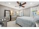 Comfortable bedroom with ceiling fan, large windows, and a stylish bed and dresser at 2121 Karns Pl, Raleigh, NC 27614