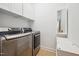 Bright laundry room with white cabinets, stainless steel washer and dryer, and natural light at 2121 Karns Pl, Raleigh, NC 27614