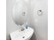 Clean powder room featuring a white sink and an oval mirror, providing a functional space at 216 Climbing Ivy Ct, Cary, NC 27511