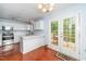 Bright kitchen featuring white cabinets, stainless appliances, breakfast bar, and deck access at 216 Climbing Ivy Ct, Cary, NC 27511