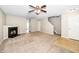 Spacious living room featuring a fireplace, ceiling fan, and staircase access at 216 Climbing Ivy Ct, Cary, NC 27511