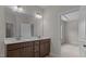Dual sink vanity with a large mirror in bathroom with a view to bedroom at 2501 Macedonia Pine Dr, Raleigh, NC 27616