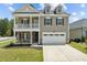 Inviting two-story home with a charming covered porch and attached two-car garage at 2501 Macedonia Pine Dr, Raleigh, NC 27616
