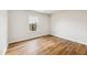 Bright and airy bedroom with hardwood floors, neutral paint, and a large window overlooking the yard at 2527 Girvan Dr, Fuquay Varina, NC 27526