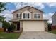 Charming two-story home featuring tan siding, black shutters, and a two-car garage at 2527 Girvan Dr, Fuquay Varina, NC 27526
