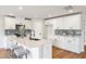 Bright kitchen with white cabinets, stainless steel appliances, and a center island with barstool seating at 2527 Girvan Dr, Fuquay Varina, NC 27526