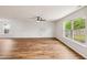 Spacious living room with wood-look floors, ceiling fan, and bright windows at 2527 Girvan Dr, Fuquay Varina, NC 27526