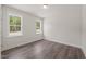 Bright bedroom features two windows offering lots of natural light and modern, wood-look floors at 260 Pilot Ridge Rd, Zebulon, NC 27597