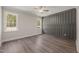 Spacious bedroom featuring wood floors, a modern accent wall, two windows, and a ceiling fan at 260 Pilot Ridge Rd, Zebulon, NC 27597