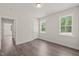 Comfortable bedroom with two bright windows and wood-look floors featuring closet and en-suite entry at 260 Pilot Ridge Rd, Zebulon, NC 27597
