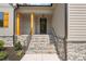 Inviting front porch with stone steps and stained wood columns provide a cozy entryway at 260 Pilot Ridge Rd, Zebulon, NC 27597