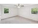 Bright bedroom with neutral carpet, ceiling fan and two windows for ample sunlight at 2606 Newquay St, Durham, NC 27705