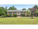 Charming brick ranch with solar panels, a well-maintained lawn, and mature landscaping at 2606 Newquay St, Durham, NC 27705