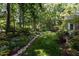 Secluded backyard featuring lush landscaping, mature trees, and well-manicured lawn at 27425 Walker, Chapel Hill, NC 27517