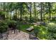Backyard stone patio area surrounded by lush landscaping and mature trees at 27425 Walker, Chapel Hill, NC 27517