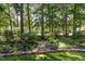Beautiful backyard landscape with stone accents, mature trees, and garden at 27425 Walker, Chapel Hill, NC 27517