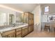 Bathroom featuring double sinks, custom wood cabinetry, and step-in shower at 27425 Walker, Chapel Hill, NC 27517