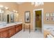 Elegant bathroom with double vanity, framed mirror, chandelier, and soaking tub for ultimate relaxation at 27425 Walker, Chapel Hill, NC 27517