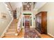 Inviting foyer with staircase, hardwood floors, area rug, and coat closet at 27425 Walker, Chapel Hill, NC 27517
