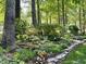 Landscaping with colorful flowers, mature trees, and stone border at 27425 Walker, Chapel Hill, NC 27517