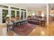 An inviting living room showcasing a tufted leather sofa, antique rug, and ample natural light at 27425 Walker, Chapel Hill, NC 27517