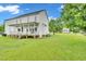 Expansive backyard with a charming two-story home, wooden deck, and lush green grass at 31 Bucking Saddle Way, Willow Springs, NC 27592