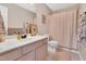 Cozy bathroom features a vanity with ample counter space, toilet, framed art, and a shower with a curtain at 31 Bucking Saddle Way, Willow Springs, NC 27592