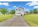 A long driveway leads to a white home with an attached garage and a well-manicured lawn at 31 Bucking Saddle Way, Willow Springs, NC 27592