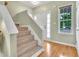 Inviting entryway featuring a carpeted staircase, light green walls, and a window allowing natural light to fill the space at 31 Bucking Saddle Way, Willow Springs, NC 27592