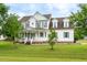 Charming two-story home with a welcoming front porch and beautifully landscaped front yard at 31 Bucking Saddle Way, Willow Springs, NC 27592