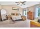 Cozy main bedroom features a ceiling fan, large bed, comfortable textiles, and plenty of natural light from the windows at 31 Bucking Saddle Way, Willow Springs, NC 27592
