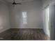 Bedroom showcasing a window, ceiling fan, wood-look floors, and barn door at 310 E Woodall St, Smithfield, NC 27577