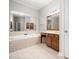 Bathroom features a large tub, vanity with cabinets, and large mirror reflecting the bright space at 312 Bridgegate Dr, Cary, NC 27519