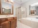 Primary bath featuring large soaking tub, glass enclosed shower, and double sink vanity at 312 Bridgegate Dr, Cary, NC 27519