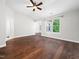 A large bedroom with dark wood floors, a ceiling fan and large window overlooking a green yard at 312 Bridgegate Dr, Cary, NC 27519