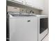 A laundry room with a white, front-load washer and dryer, providing convenience for laundry chores at 312 Bridgegate Dr, Cary, NC 27519