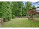 Fenced backyard with a wood deck, lawn and view of the surrounding trees at 317 Chamberlain Dr, Clayton, NC 27527