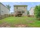 Fenced backyard with a wood deck, lawn and view of other homes in the neighborhood at 317 Chamberlain Dr, Clayton, NC 27527