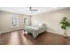 Bedroom with dark floors, neutral walls, a tray ceiling with fan, and dual windows at 317 Chamberlain Dr, Clayton, NC 27527