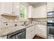 Kitchen with white cabinets, granite countertops, stainless steel appliances, and view to the backyard at 317 Chamberlain Dr, Clayton, NC 27527