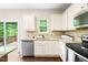 Well-lit kitchen featuring granite countertops, white cabinets, stainless steel appliances, and a view to the outdoor deck at 317 Chamberlain Dr, Clayton, NC 27527