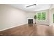 Open living room featuring a fireplace, hardwood floors, and a bright window at 317 Chamberlain Dr, Clayton, NC 27527