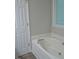 Bathroom featuring a soaking tub, window, and access door in a neutral color scheme at 3300 Neuse Crossing Dr, Raleigh, NC 27616