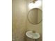 Cozy powder room featuring golden fixtures, a round mirror, and textured wallpaper at 3300 Neuse Crossing Dr, Raleigh, NC 27616