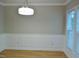 Dining room with hardwood floors, wainscoting, modern lighting, and natural light from large windows at 3300 Neuse Crossing Dr, Raleigh, NC 27616