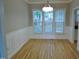 Dining room with hardwood floors, wainscoting, modern lighting, and natural light from large windows at 3300 Neuse Crossing Dr, Raleigh, NC 27616
