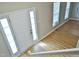 Bright entryway with wood-look flooring, staircase and a white front door flanked by sidelight windows at 3300 Neuse Crossing Dr, Raleigh, NC 27616