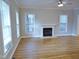 Cozy living room with a fireplace, hardwood floors, neutral paint and natural light from large windows at 3300 Neuse Crossing Dr, Raleigh, NC 27616